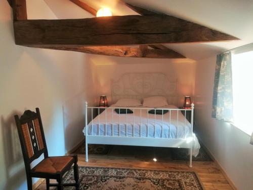 une chambre avec un lit blanc dans un grenier dans l'établissement Gites de la noue, à Vendrennes