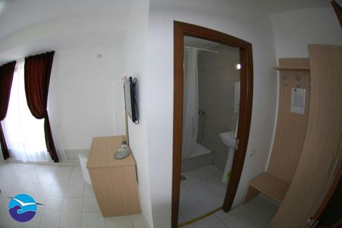 a bathroom with a toilet and a television in it at Casa Sagrada in Eforie Nord