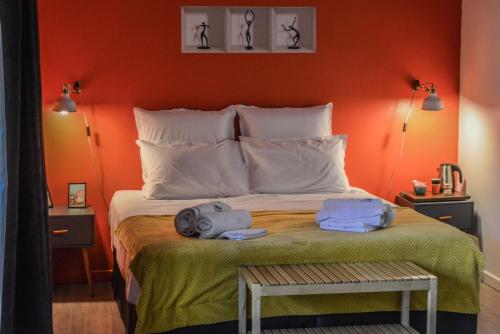 a bedroom with a bed with orange walls at La Grande Oasis - B&B et Spa in Grazac