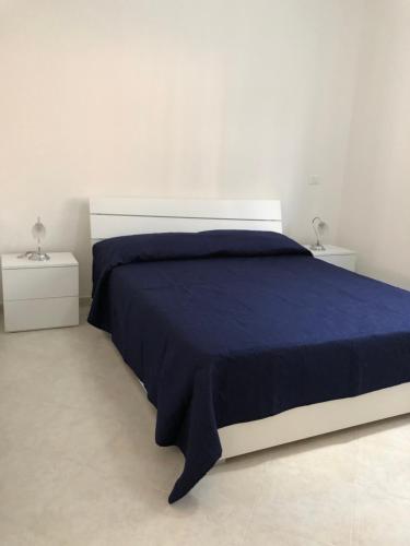 1 dormitorio con 1 cama azul y 2 mesitas de noche en Pizzo Beach Club by Maralp, en Pizzo
