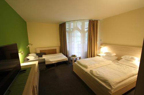 pokój hotelowy z dwoma łóżkami i telewizorem w obiekcie Grantek Üdülőház w mieście Balatonlelle