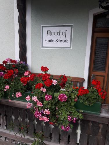 a sign for the front of a house with flowers at Moarhof in Aich