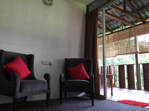 two chairs with red pillows sitting in a room at Kejora Homestay in Kangar