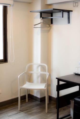 a white chair sitting in a room with a desk at Nana City Hotel in Bangkok