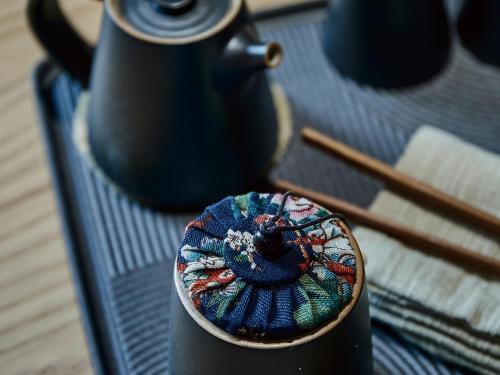a teapot sitting on a table with chopsticks at EBO Hotel Hangzhou Wulin - 5 mins drive to the West Lake in Hangzhou