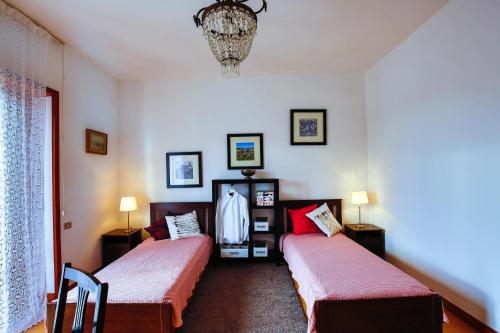 a bedroom with two beds and a chandelier at Casa in villa nel Parco del Vesuvio in Pollena Trocchia