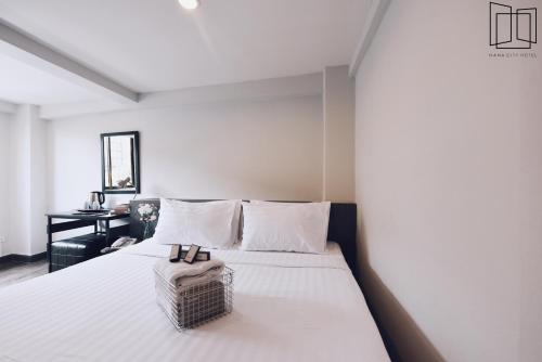 a bedroom with a white bed with a basket on it at Nana City Hotel in Bangkok