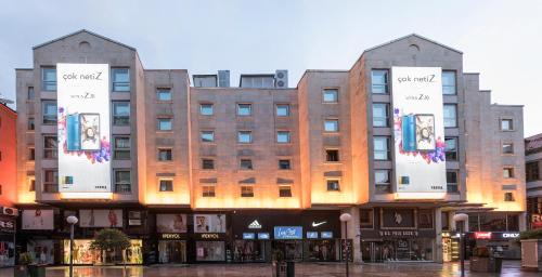 un gran edificio con letreros en la parte delantera en Zorlu Grand Hotel Trabzon en Trebisonda