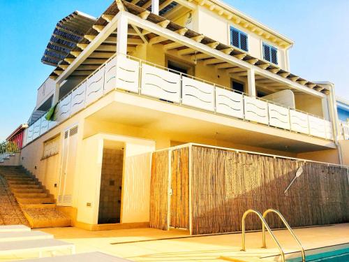 ポッツァッロにあるVilla Sea Sky - Sicily Inのスイミングプールの隣にバルコニー付きの建物