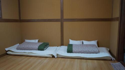 two beds sitting next to each other in a room at Haengjin Guesthouse in Jeonju