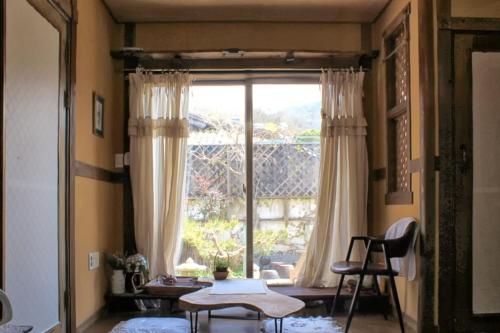 a living room with a large window and a table at Haengjin Guesthouse in Jeonju