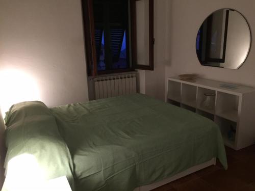 a bedroom with a green bed and a mirror at Appartamento vacanze "Borgo Cinque Terre" Volastra Manarola in Volastra