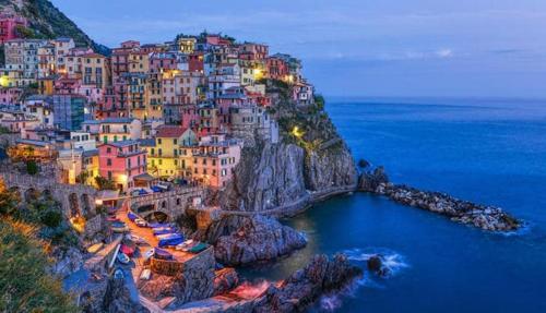 a group of buildings on a hillside with the ocean at Appartamento vacanze "Borgo Cinque Terre" Volastra Manarola in Volastra