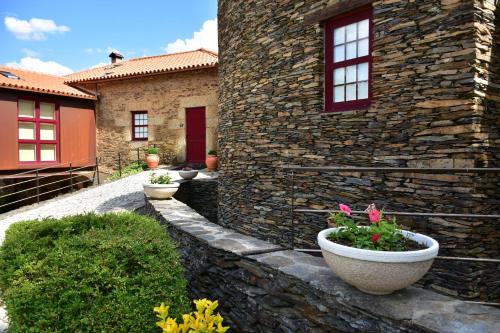 a stone building with some plants in front of it at Casa Lagar Da Alagoa in Manteigas