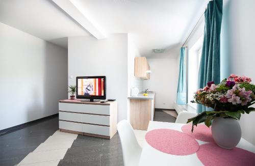 una sala de estar con TV y un jarrón de flores en PORT-ŁÓDŹ Apartment by PinPoint en Lodz