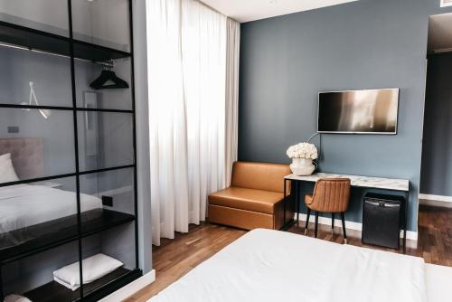 1 dormitorio con cama, escritorio y silla en Abokamento Boutique Rooms, en Split