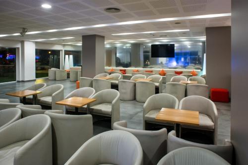 an empty waiting room with tables and chairs at Hotel Montecarlo Spa & Wellness in Roses