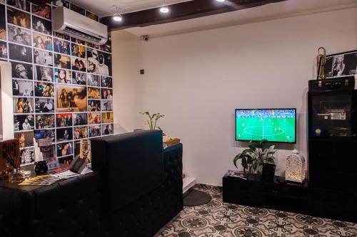 a room with a television and a wall with pictures at Backstage Boutique Music Themed Townhouse in Sliema