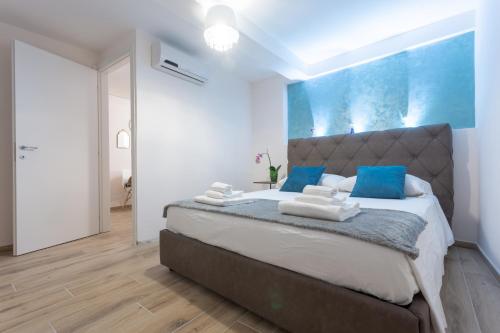 ein Schlafzimmer mit einem großen Bett mit blauen Akzenten in der Unterkunft Venexia House to Rialto in Venedig