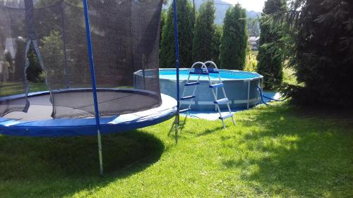 an empty trampoline in the grass next to a pool at Dom Wypoczynkowy Grań in Białka Tatrzańska