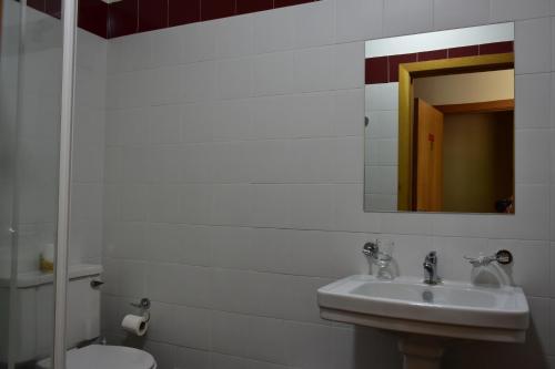 a bathroom with a sink and a toilet and a mirror at Casa Lagar Da Alagoa in Manteigas