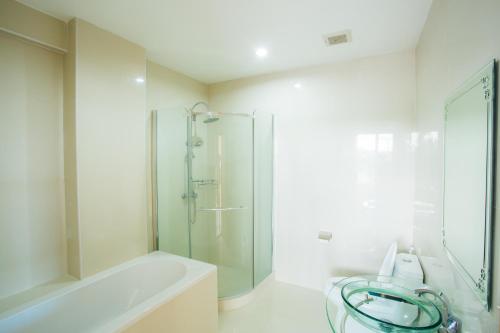 y baño con ducha de cristal y bañera. en Kanokan Hotel, en Kanchanaburi