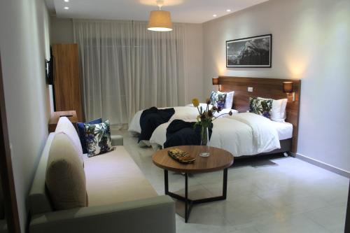 um quarto com uma cama, uma mesa e um sofá em L'escale Suites Résidence Hôtelière By 7AV HOTELS em Mohammedia