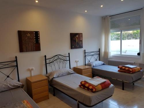 a bedroom with two beds and a window at Albergue Ciudad del Doncel in Sigüenza