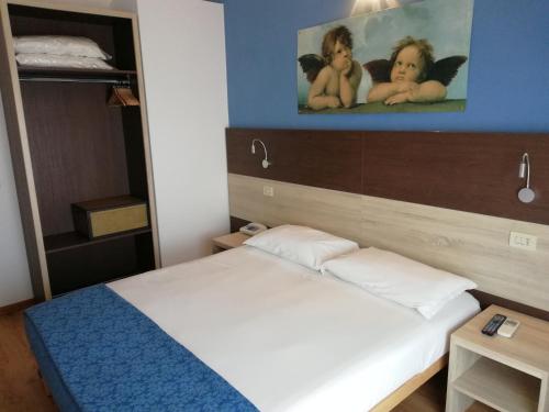 a small bedroom with a bed and a painting on the wall at Hotel Lory My Wellness SPA in Chianciano Terme