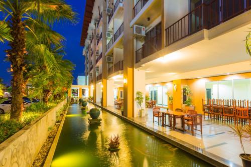 an external view of a hotel with a pond in the middle at Kanokan Hotel in Kanchanaburi