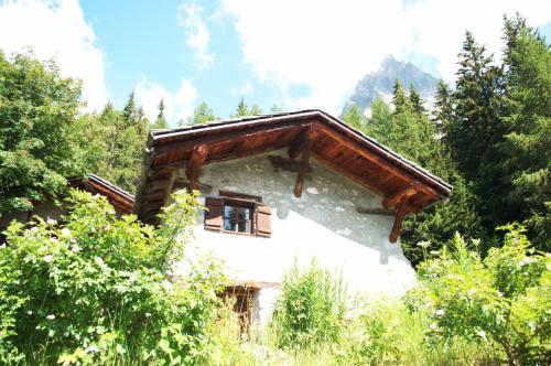 a house with a wooden roof in the woods at Rochefort Valferret in Courmayeur