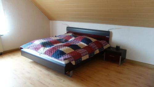 ein Schlafzimmer mit einem Bett mit einer Decke darauf in der Unterkunft Ferienwohnung Tine in Oberhausen
