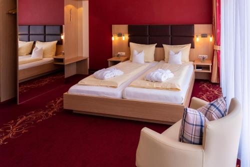 ein Hotelzimmer mit 2 Betten und einem Spiegel in der Unterkunft Komfort-Hotel Katerberg in Lüchow