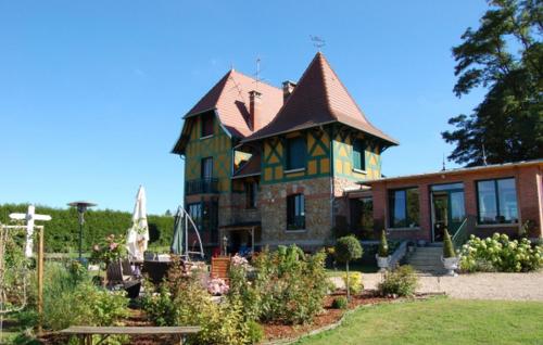 a large house with a turret in a garden at Un Air de Campagne in Couloisy