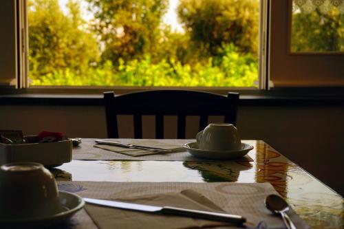 een tafel met een kopje en schoteltjes en een raam bij Lemon Factor Sorrento in Sorrento