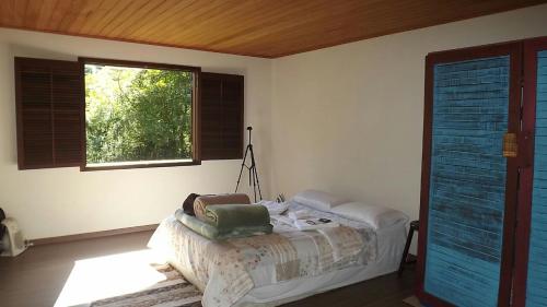 a bedroom with a bed and a window at Refúgio Guapuruvu in Lumiar