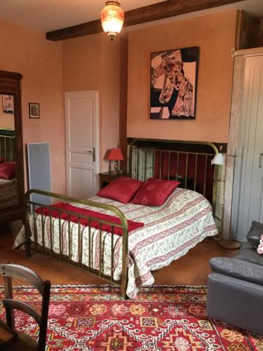 a bedroom with a bed with red pillows on it at "Au campaner" chambres dans maison gasconne in Barran