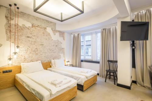 a hotel room with two beds and a flat screen tv at R34 Boutique Hotel in Sofia
