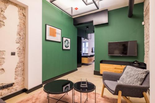 a living room with a green wall and a couch and a tv at R34 Boutique Hotel in Sofia
