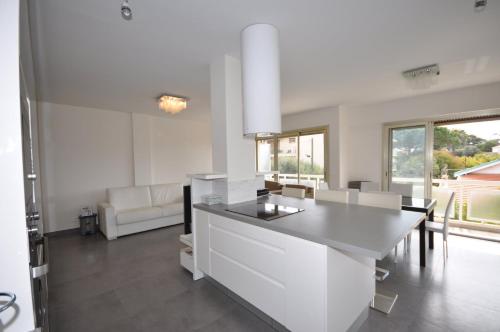 Una cocina con gabinetes blancos y una mesa y sillas. en SPLENDIDE 3 PIECES VUE MER, en Antibes