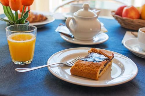 une assiette avec un morceau de gâteau et un verre de jus d'orange dans l'établissement Appartamento Gli Ontani, à Cala Liberotto