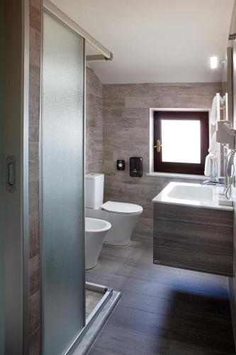 a bathroom with two toilets and a sink and a tub at Locanda San Giorgio in Neviglie