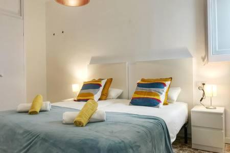 Un dormitorio con dos camas con almohadas de colores. en Casita de pescador III, en Calafell