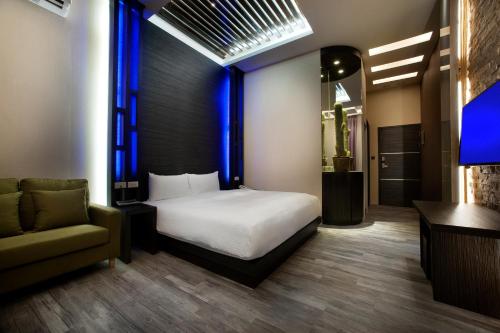 a bedroom with a bed and a couch and a chair at Two Fukun Hotel in Jiaoxi