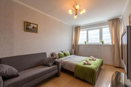 モスクワにあるAG Apartment on Tamojennii proezdのベッドルーム1室(ベッド1台、ソファ、窓付)