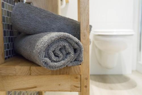 einen Haufen Handtücher, die auf einem Regal neben einer Toilette liegen in der Unterkunft Moderne 70 qm Wohnung mit großer Dachterrasse in Kinheim