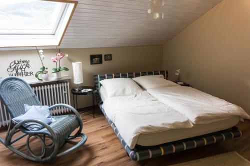 KinheimにあるModerne 70 qm Wohnung mit großer Dachterrasseのベッドルーム1室(ベッド1台、椅子、窓付)