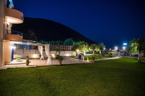 a building with a lawn in front of a building at Akroyiali Resort in Vasiliki