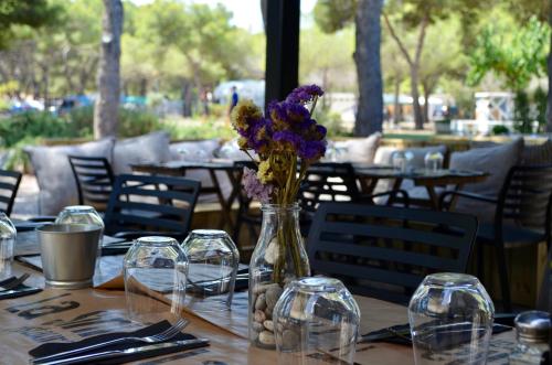 a table with a vase with purple flowers in it at HolaCamp Sitges Garrofer in Sitges