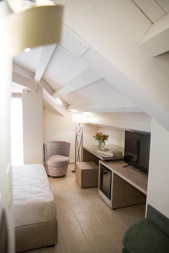 a room with a bed and a desk with a television at Attico in Canicattì